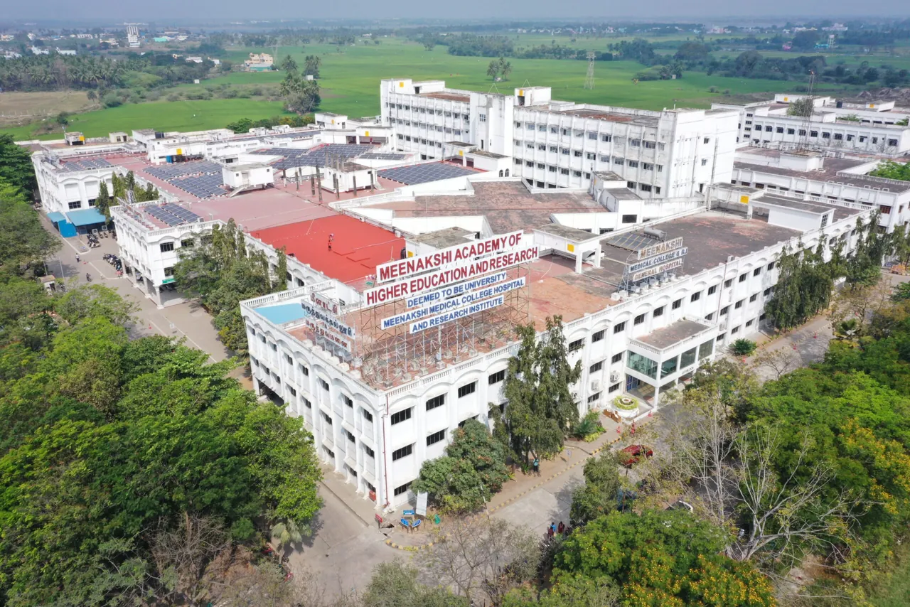 An aerial view of the Meenakshi Medical College Hospital and Research Institute campus, with the college name on the roof of the main block