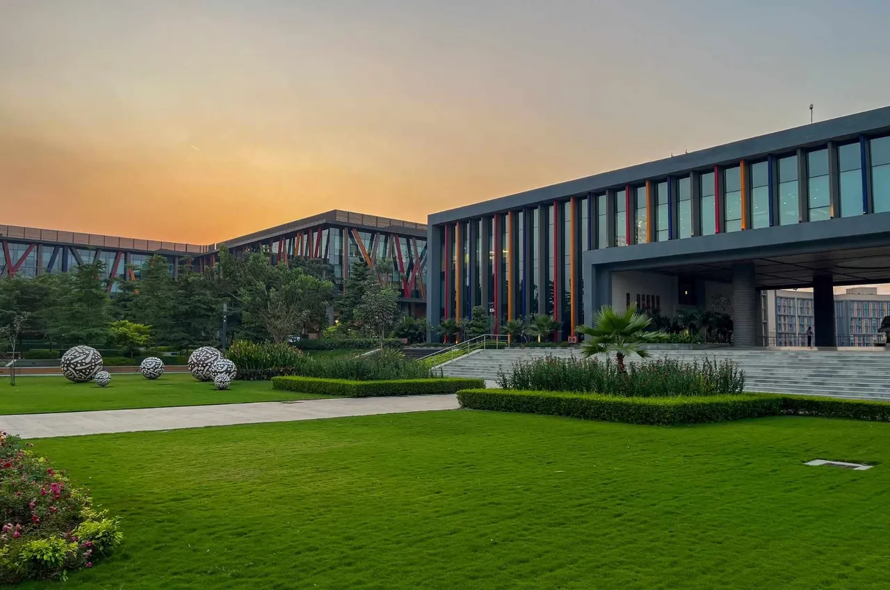 The academic building of the BITS Pilani Mumbai campus (where BITSoM sits) across the front lawn at sunset.