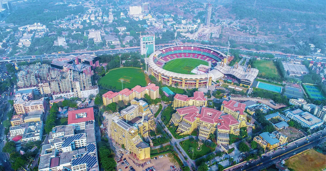 Drone view of the D. Y. Patil campus at Nerul, Navi Mumbai, with the red-roofed university buildings and the stadium behind. Hosted on the university's own S3 bucket used by dypatil.edu.