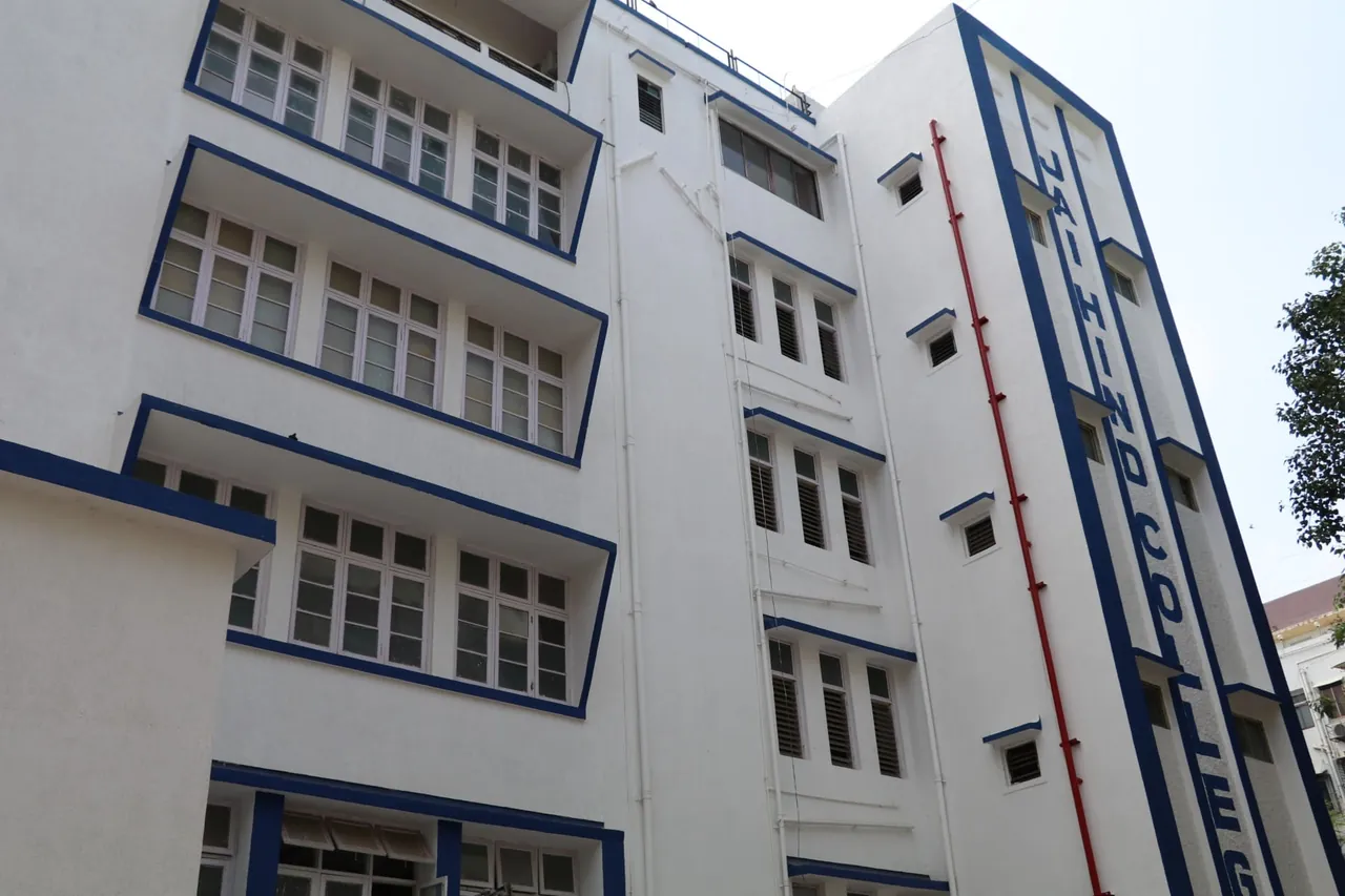 The main building of Jai Hind College from the street, white with blue trim, the college name running down the facade.