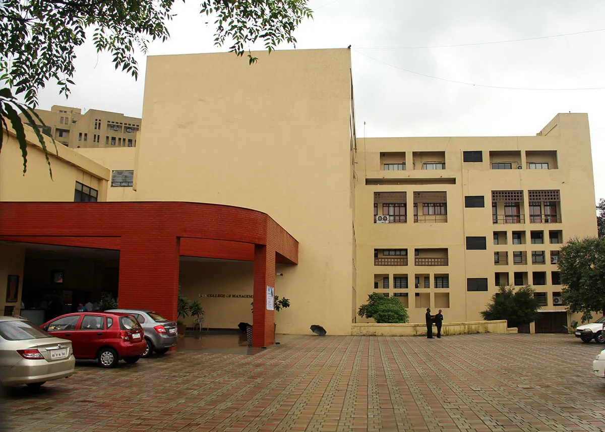 The cream-yellow SIES building with its red entrance canopy and paved forecourt. Note: the site's Infrastructure page shows a different, white-and-blue building as 'campus' (https://siessbs.edu.in/images/campus.jpg, 1200 x 800); the founder may prefer that one.