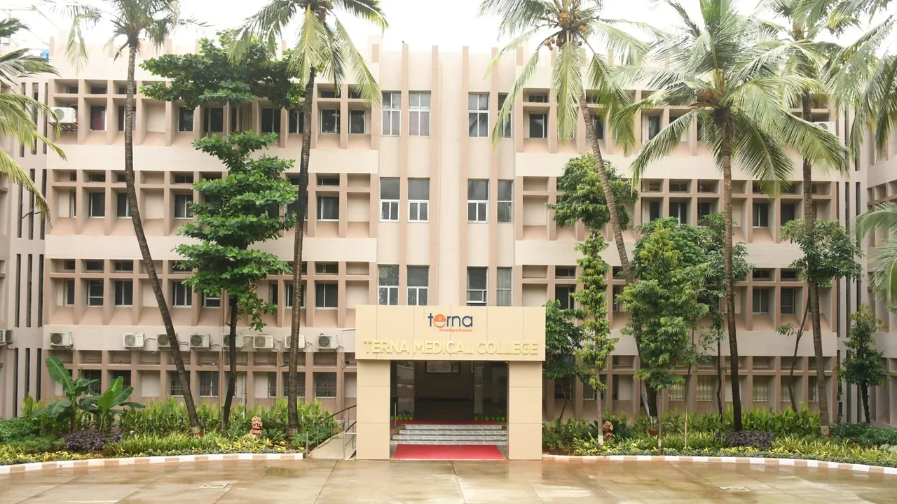 The front of Terna Medical College: the entrance with the Terna name, the building behind a row of palm trees.