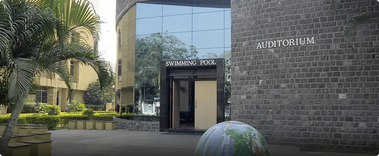 The Symbiosis Infotech Campus at Hinjewadi where SCMHRD sits: the stone auditorium and swimming-pool block with palms in front. It is a facilities building, not the main academic block